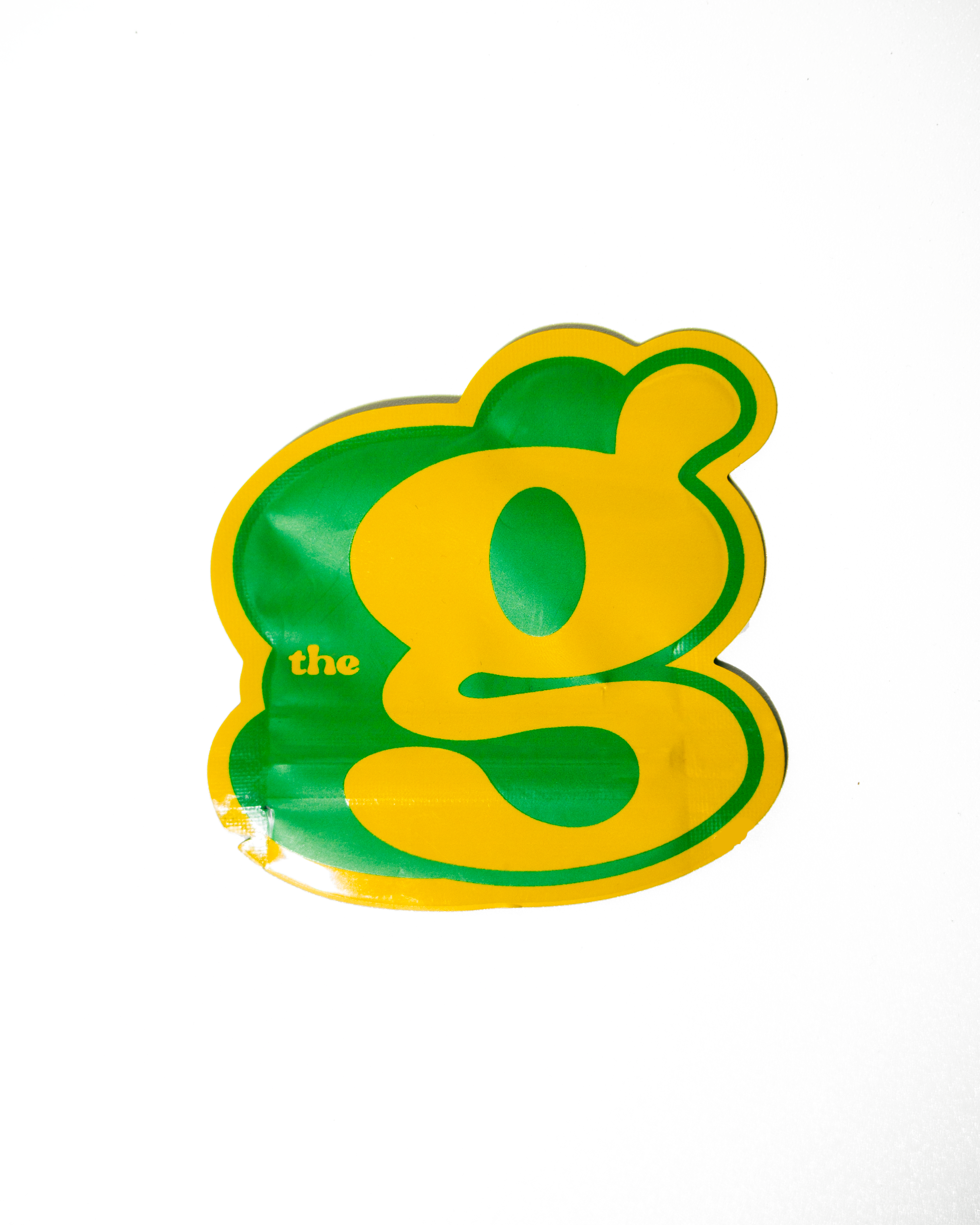 Two translucent, irregular pieces of amber-colored cannabis concentrate shatter with small bubbles.